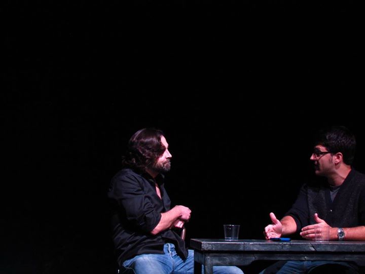 Sleazy Tom (Tom Blank) listens to Trevor (Joe Boothe) talk about his writer's block.
