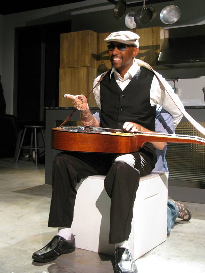 Bluesman Blind Lemon Custard (Victor Isaac) and his guitar-playin' hands (Korey Simeone).